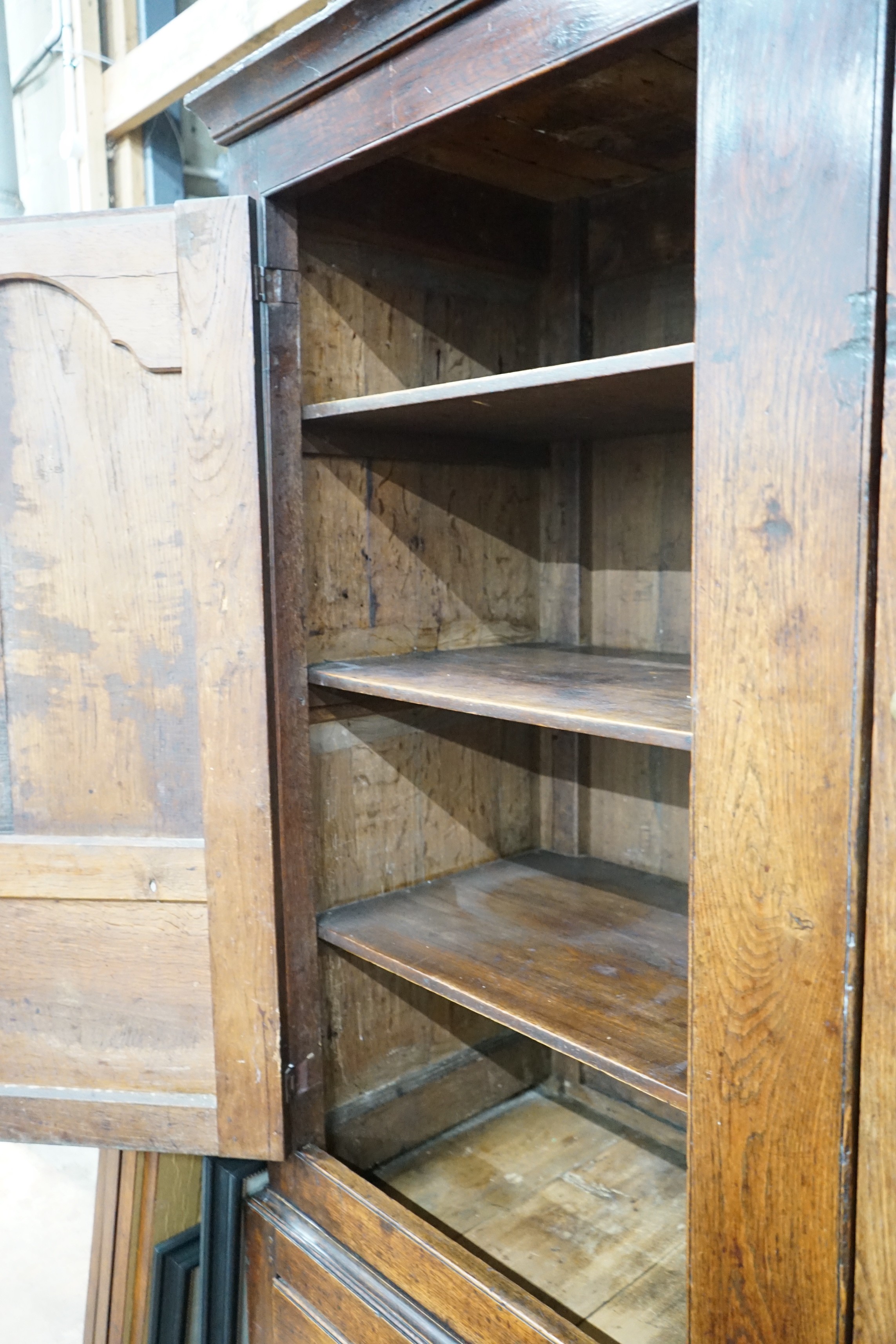 An 18th century oak hanging cupboard with later shelved interior, width 145cm, depth 56cm, height 199cm